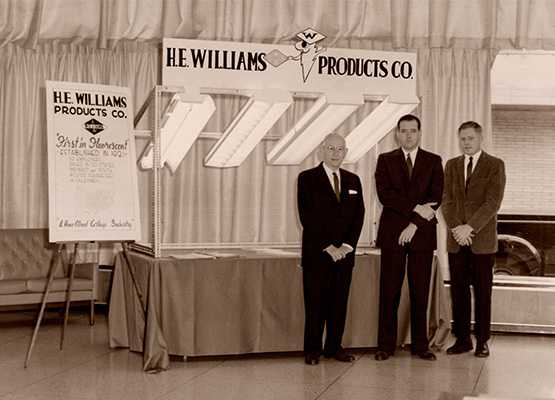 H.E. Williams and John Williams showcasing fixtures with the First in Fluorescent slogan