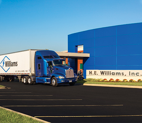 Williams truck and trailer in front of the H.E. Williams, Inc. office entrance
